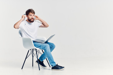 man sitting on a chair with headphones laptop