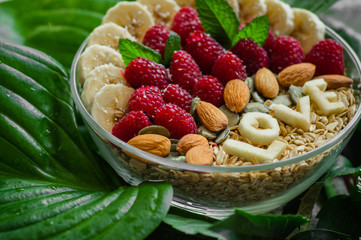 Eating healthy breakfast bowl. The word LOVE in a plate with a healthy meal. Raspberry, Banana, Nuts. Vegetarian food concept
