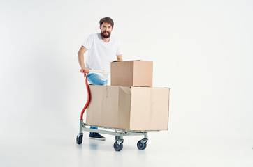 man rolls a cart with boxes