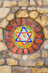 Fototapeta na wymiar Mosaic star of David on stone wall.