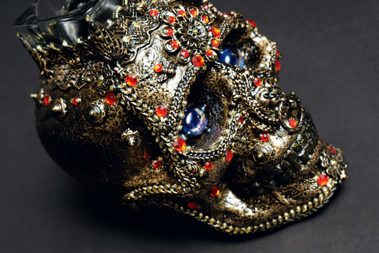 Skull decorated with colorful stones on black background