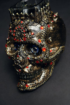 Skull decorated with colorful stones on black background