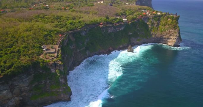 Pura Uluwatu temple. Stone cliffs, ocean waves and ocean landscape. Aerial view. Bali island, Indonesia.