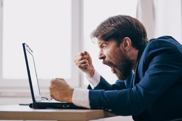 business man shouting at a laptop