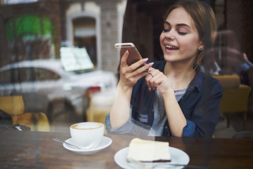woman takes a picture of food in a cafe window
