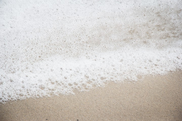 Closeup white foam from sea wave on the beach,beauty by nature
