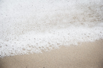 Fototapeta na wymiar Closeup white foam from sea wave on the beach,beauty by nature