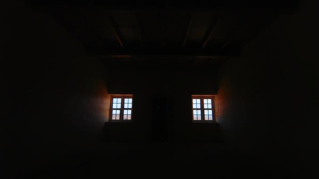 Interior, bright light shining through windows of dark abandoned house