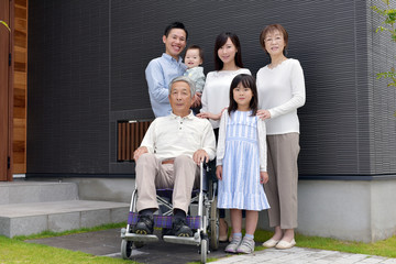 車椅子のシニア男性と3世代家族