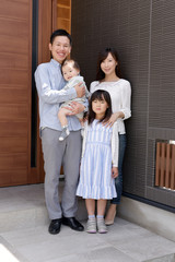 自宅前に立つ笑顔の家族