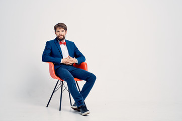 man in a suit sitting on a chair