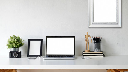 Desk, workspace with laptop and office supplies.