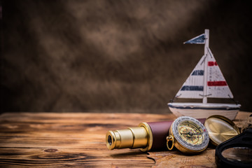 Columbus Day. Vintage worldmap and discovery equipment. Copy space on dark wood background.