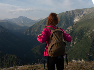 Fototapeta na wymiar trip woman in pink jacket with backpack in the mountains nature travel
