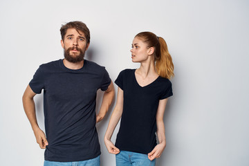 young couple in black t-shirts on a light isolated background