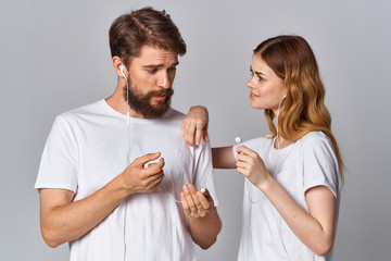 young couple in white t-shirts with headphones logo