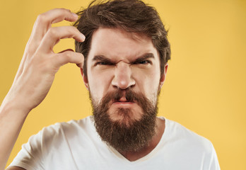 Fototapeta premium angry man with a beard on a yellow background portrait