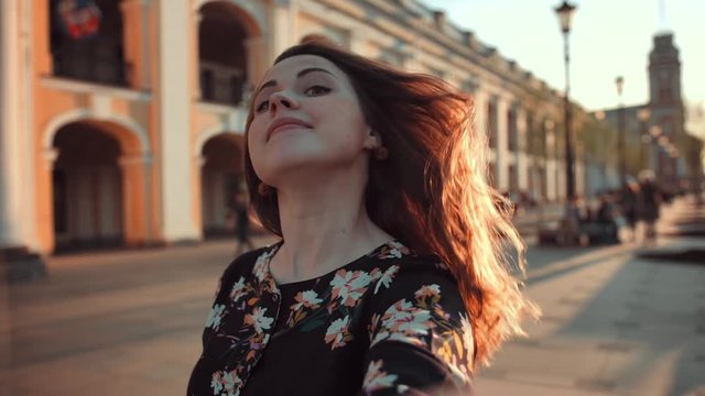POV footage of Selfie of funny attractive sexy handsome girl with freckles. Sunny evening. Lightleaks. She happy smiling and laughing, combing her red hair. Wide lens. Close-up of face.