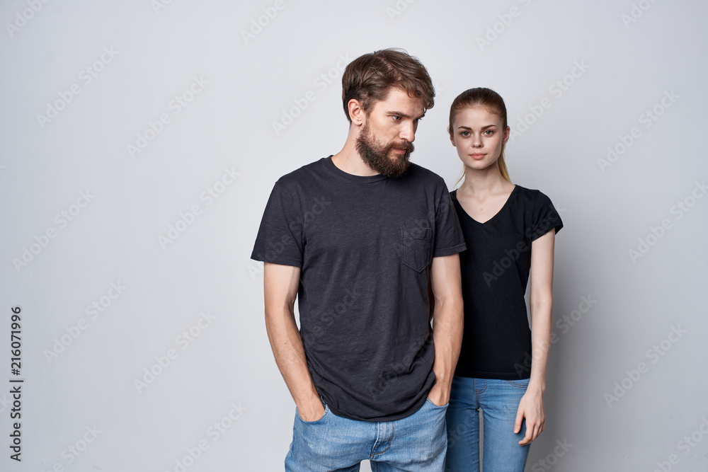 Wall mural young couple in black logo shirts