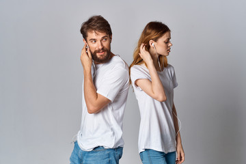 Fototapeta premium young couple in white t-shirts listening in headphones music logo