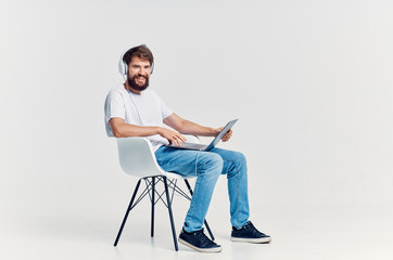 man sitting on a chair with a laptop with headphones