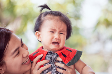 Sad asian baby girl crying and mother comforting her with love