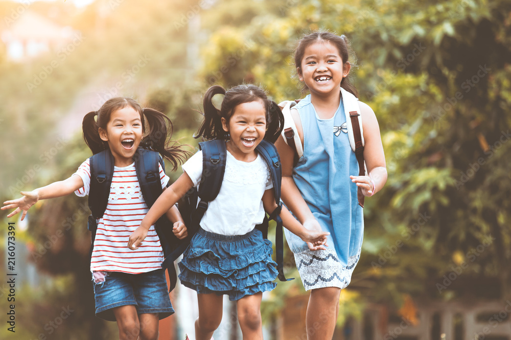 Wall mural back to school. asian pupil kids with backpack running and going to school together with fun and hap