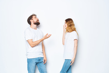 young couple talking in white t-shirts on a light background