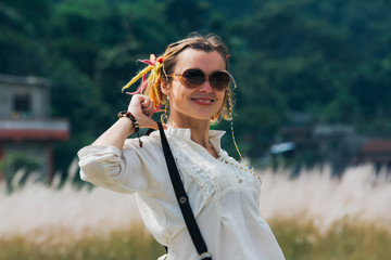 Relaxed young woman in a meadow by the forest in the village