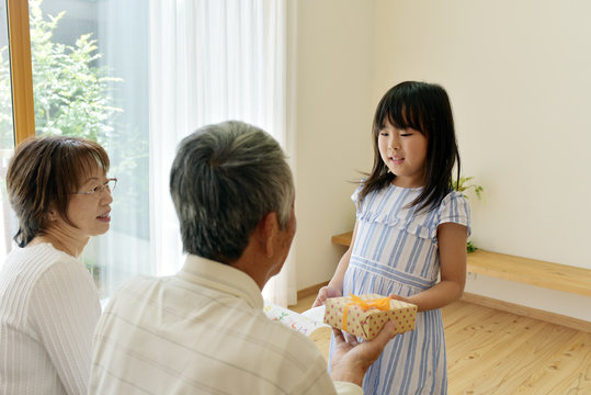 おじいちゃんにプレゼントを渡す女の子