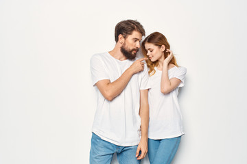 Fototapeta premium young couple in white t-shirts on a light background place free logo