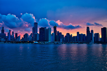 Sunset over city of Chicago create shadows of the skyline, seen from Lake Michigan during summer boat ride.