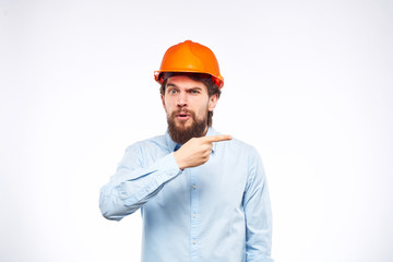 male builder in an orange helmet points his finger at a free place