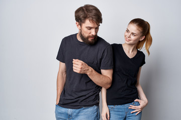 young couple in black t-shirts on a light background