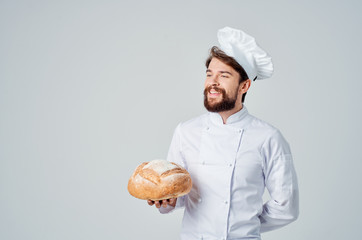 happy cook holding a round loaf of bread in his hand