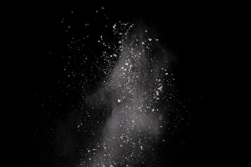 Launched white powder, isolated on black background.
