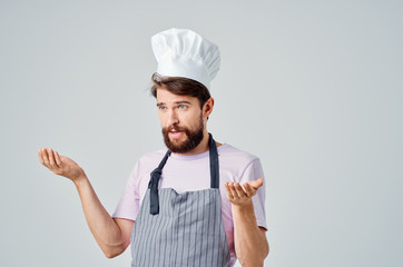 the chef in his headdress and apron spreads his hands
