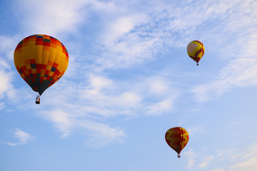 colorful hot air balloon against blue sky. hot air balloon is flying in white clouds. beautiful flying on hot air balloon