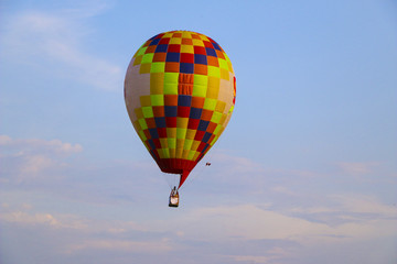 colorful hot air balloon against blue sky. hot air balloon is flying in white clouds. beautiful flying on hot air balloon
