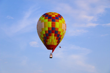 colorful hot air balloon against blue sky. hot air balloon is flying in white clouds. beautiful flying on hot air balloon