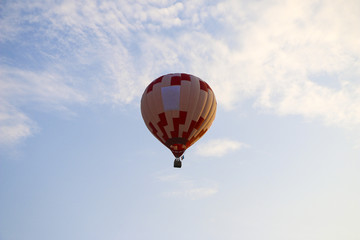 colorful hot air balloon against blue sky. hot air balloon is flying in white clouds. beautiful flying on hot air balloon