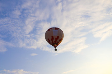 colorful hot air balloon against blue sky. hot air balloon is flying in white clouds. beautiful flying on hot air balloon