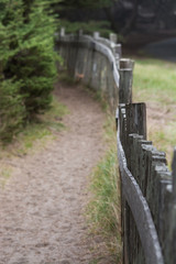 Wooden fence along pathway with sand
