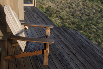 Fototapeta na wymiar Chair on wooden terrace in sunlight