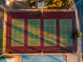 Looking down at old tennis courts at sunset - aerial view