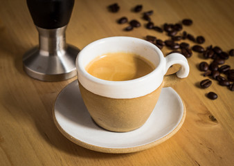 Demitasse, coffee bean and tamper.