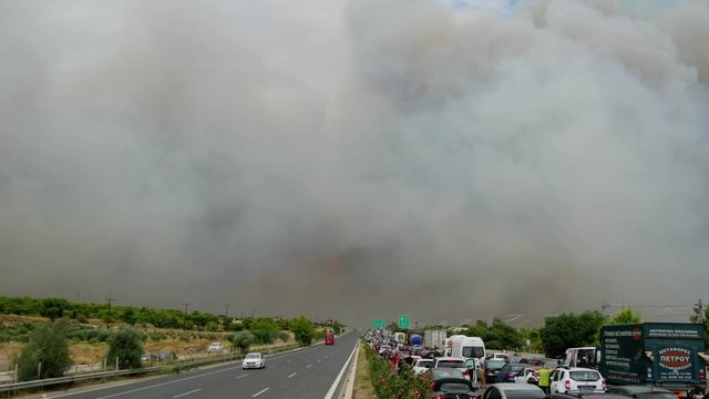 During the wildfires in Attica Greece. View of the smoke from the highway and Skycrane helicopter firefighting.