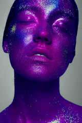 Woman space. A creative make-up of the person by means of bright paints and the poured pigments. Halloween, holidays, studio of beauty and art