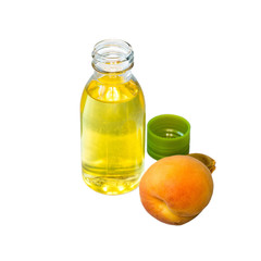   A small bottle of butter and a fresh ripe apricot on a white background.