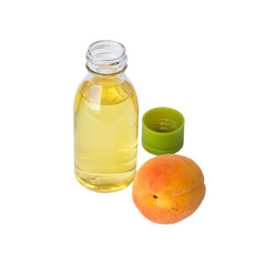   A small bottle of butter and a fresh ripe apricot on a white background.